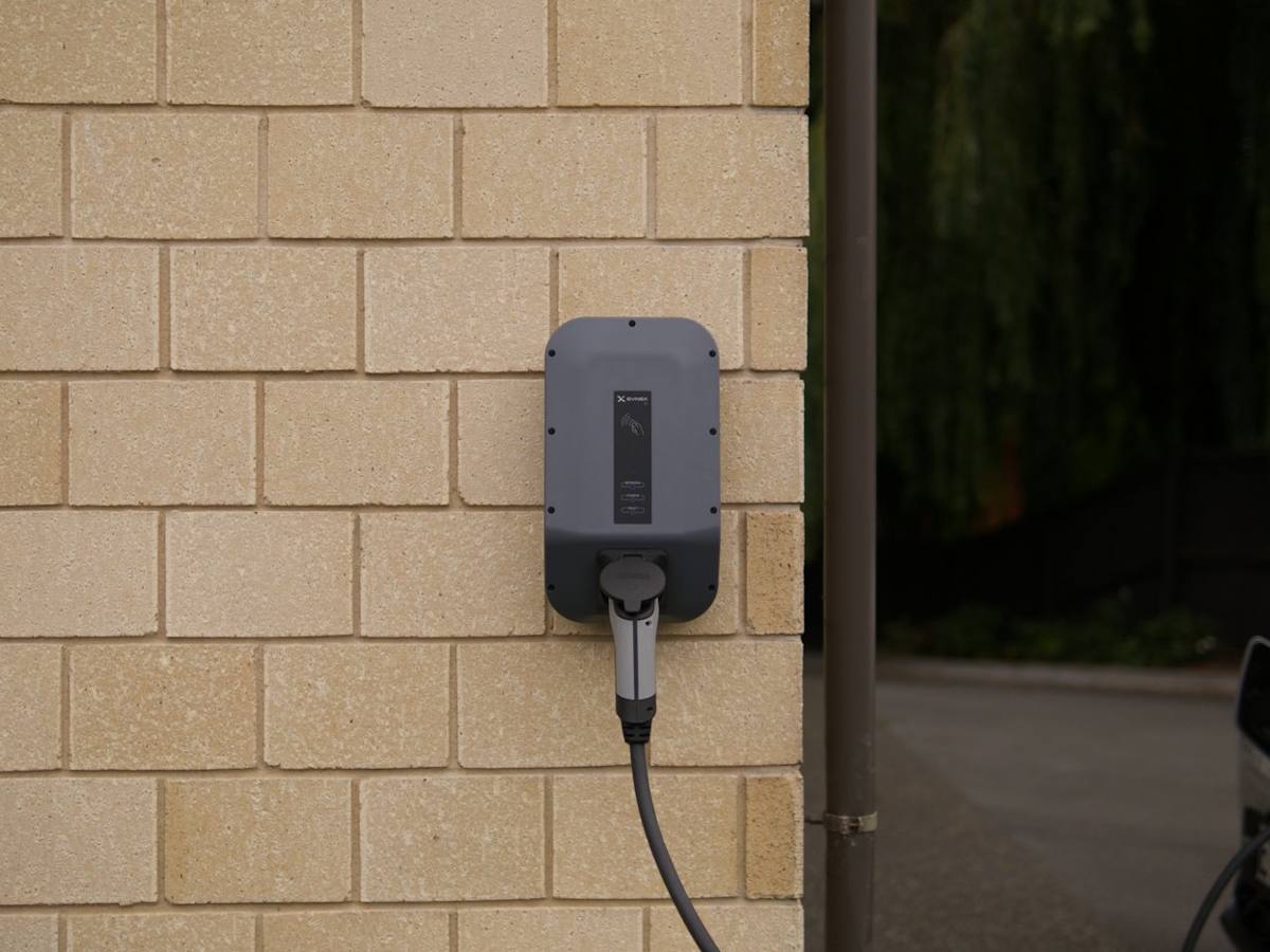 Wall-mounted electric vehicle charger on a brick wall